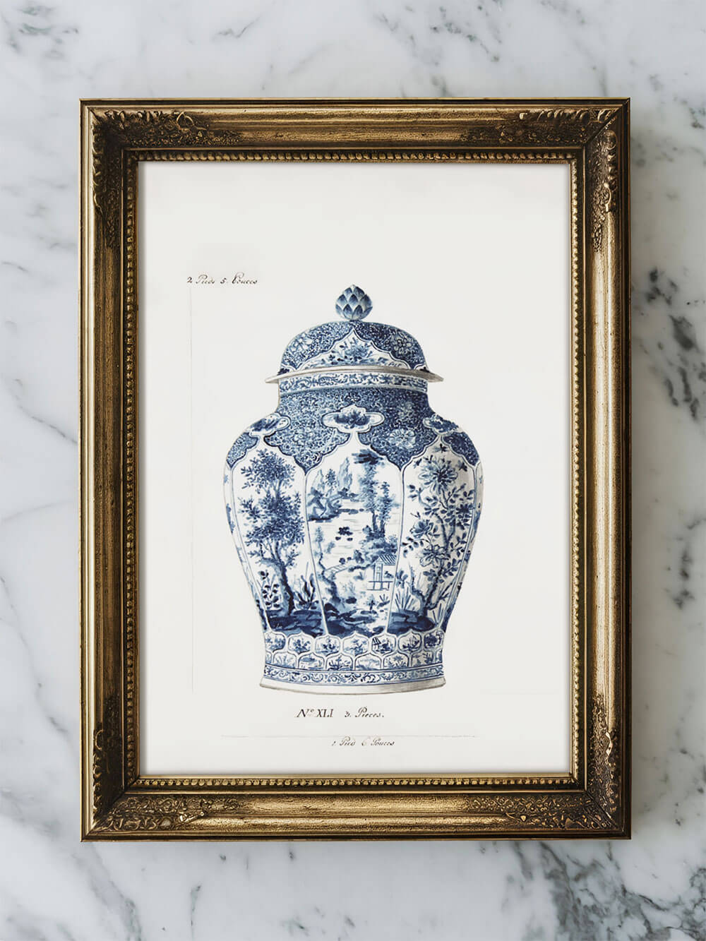 Vintage Chinoiserie Vase Kunstdruck mit detailreichen blauen und weißen Mustern, eingerahmt in einem goldenen Barockrahmen, auf einem Marmortisch platziert.