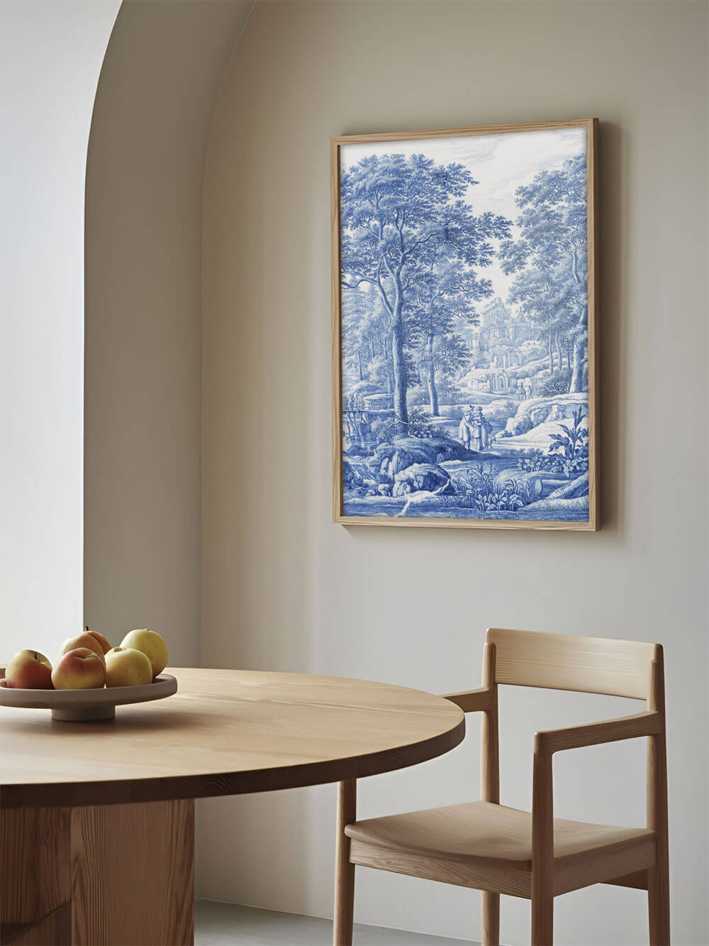 Ein einzelner blau-weißer Kunstdruck hängt an der Wand eines modernen Esszimmers. Die Landschaft zeigt Bäume, eine Brücke und eine ruhige Szene im klassischen Stil. Die minimalistische Holzeinrichtung und das natürliche Licht im Raum betonen die Ruhe und Eleganz des Kunstwerks.