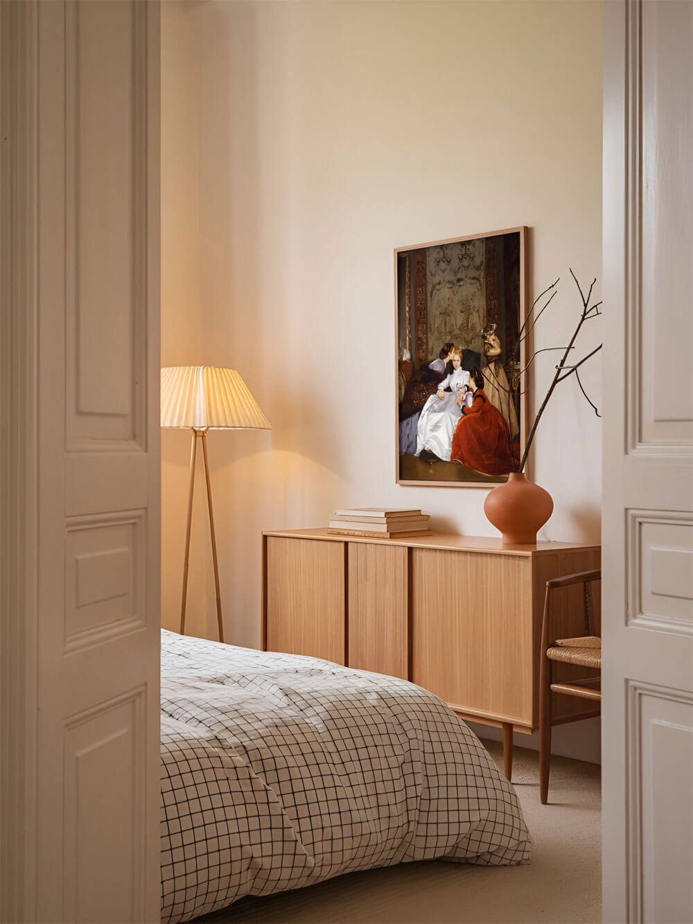 Kunstdruck 'Die zögerliche Verlobte' von Auguste Toulmouche im Schlafzimmer, aufgehängt über einem minimalistischen Holzschrank neben einer Designer-Stehlampe.