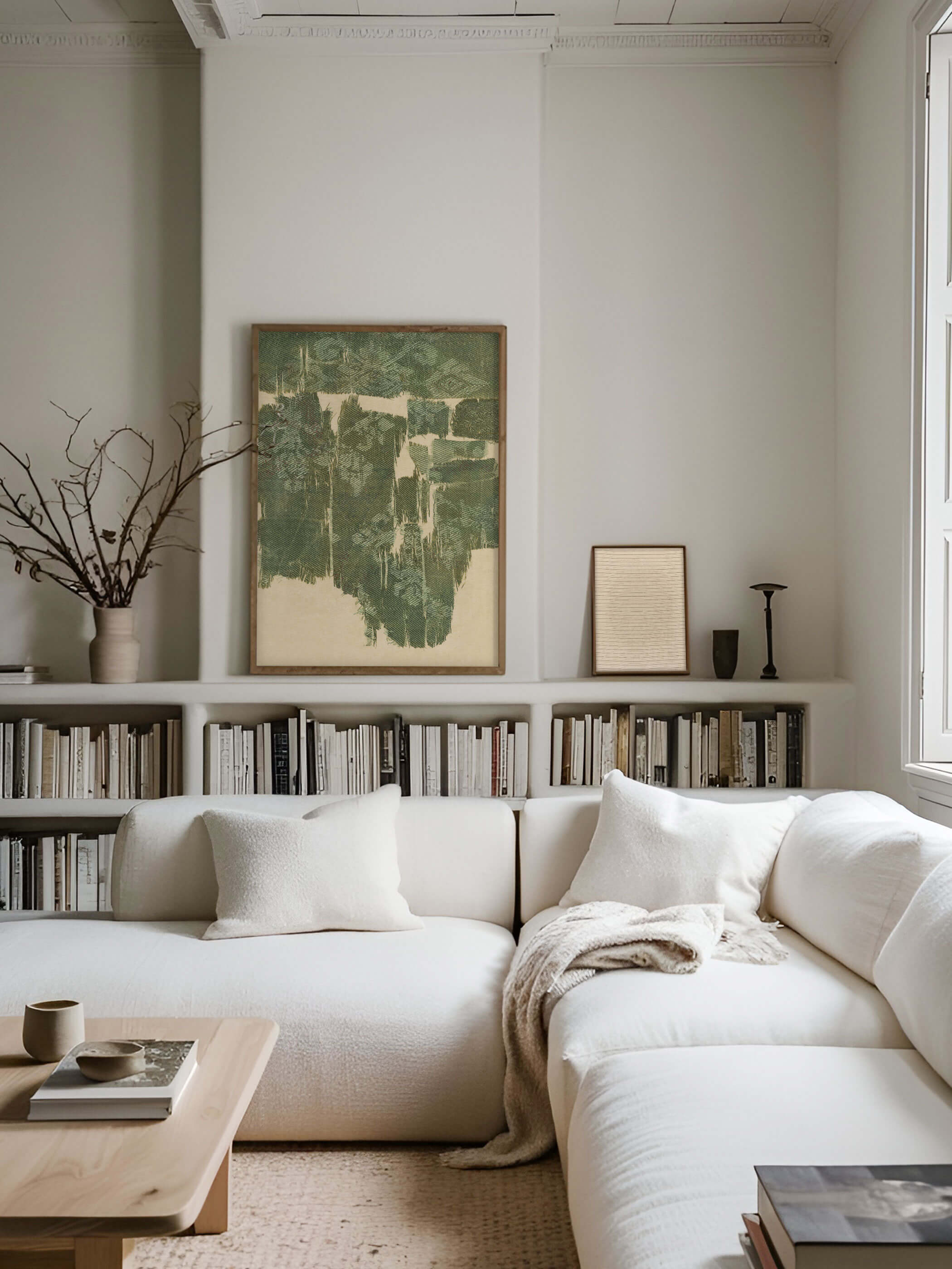 Wabi-Sabi Kunstdruck im Wohnzimmer, mit grünen geometrischen Mustern auf beiger Seide, rustikal eingerahmt und über einem weißen Sofa mit Bücherregal im Hintergrund.